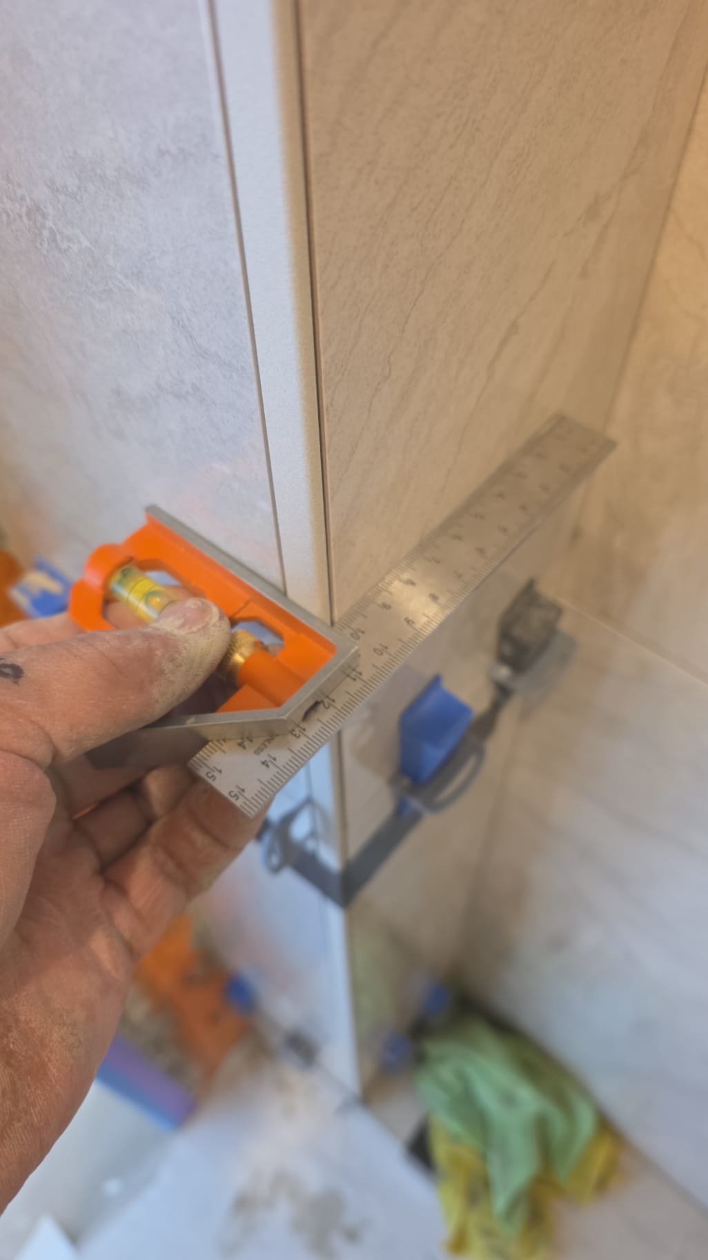 Controle van het tegelwerk met waterpas en winkelhaak