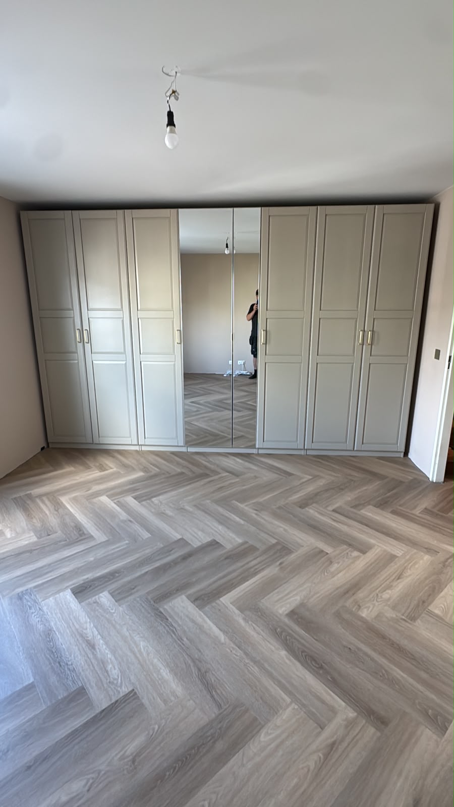 Slaapkamer met maatwerkkastenwand en visgraat PVC-vloer